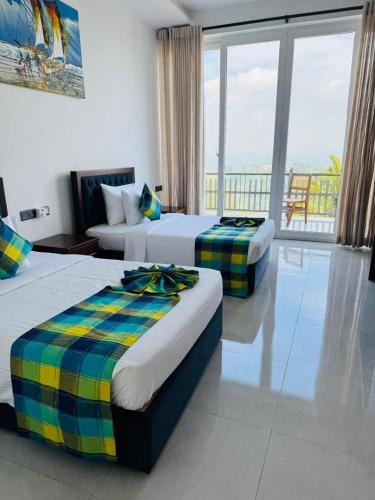 a hotel room with two beds and a balcony at The Cloud Hanthana, Kandy in Kandy