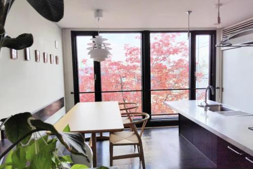 a kitchen with a table and chairs and a large window at Townhouse Asahikawa in Asahikawa