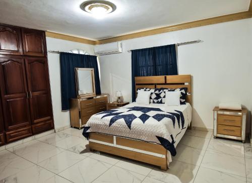 a bedroom with a bed and a dresser and a mirror at Sweet home in Jarabacoa