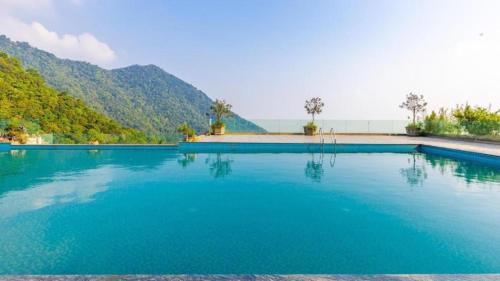 a large swimming pool with a mountain in the background at Valley Bungalow - Venuestay in Tam Ðảo