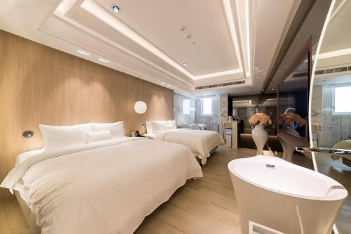 a hotel room with two beds and a sink at Uya Motel in Xinwu