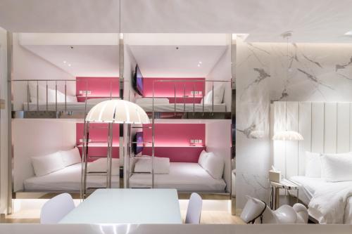 a room with pink and white furniture and a bed at Uya Motel in Xinwu