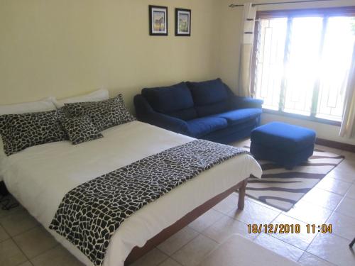 a bedroom with a bed and a blue couch at White Sands Retreat in Chintheche