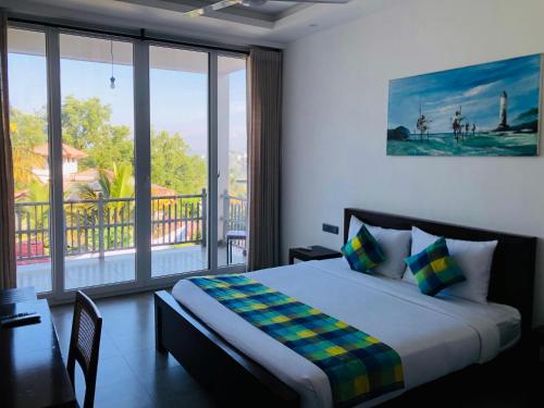 a bedroom with a bed with a view of a balcony at The Cloud Hanthana, Kandy in Kandy