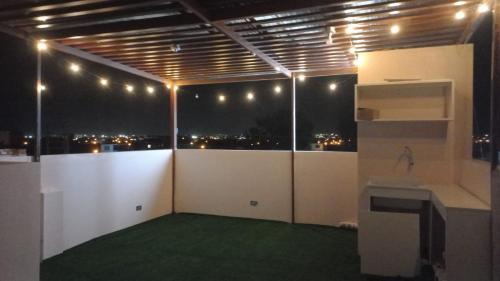 une chambre avec vue sur la ville la nuit dans l'établissement CARDOS HOSTAL, à Pisco