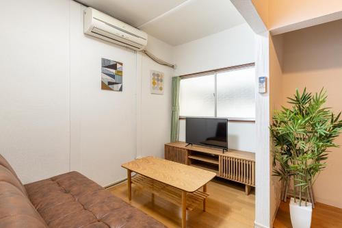 a living room with a couch and a tv at 東上野戸建 in Tokyo
