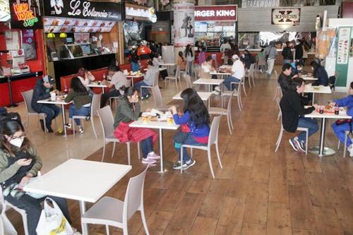 a group of people sitting at tables in a restaurant at Departamento centrico, pasos a Embajada Americana, Multicine in La Paz