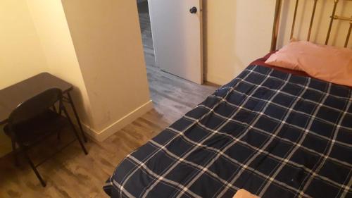 a bedroom with a bed and a table and a door at Victoria Trail Apartments in Edmonton