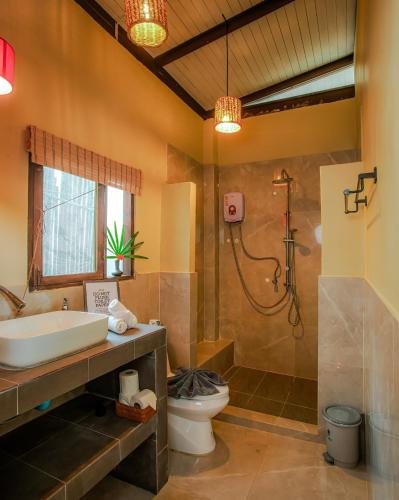 a bathroom with a sink and a toilet and a shower at Amaya Boutique Resort in Srithanu