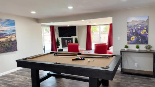 a living room with a pool table and red chairs at Private Home - Heated Pool, Billiards, Darts, Foosball, Fireplace, 5 Smart TVs, BBQ, Cotton Bedding - The Saguaro Sanctuary, Pool Heat Optional in Tucson