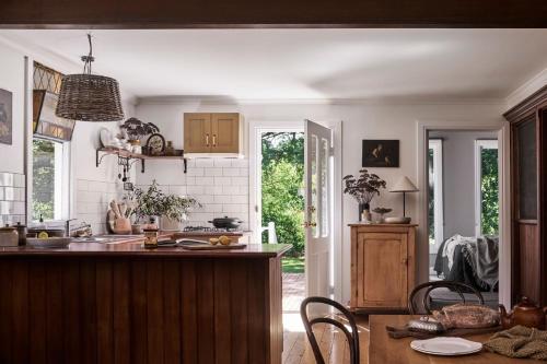 a kitchen with a sink and a table with chairs at The Church at Lyonville - Daylesford Region in Lyonville