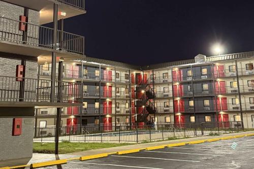 a large apartment building at night with red lights at Ramada by Wyndham Kenner New Orleans Airport South in Kenner