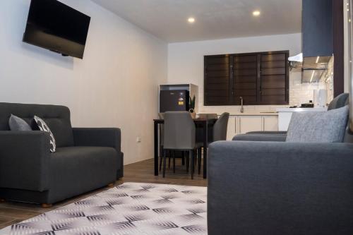 a living room with two couches and a kitchen at Garden Apartments in Nadi