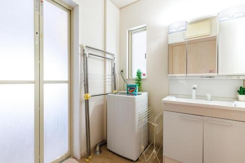 a small kitchen with a sink and a refrigerator at 恩納村一棟貸し ビーチや飲食店徒歩圏内 最大6名 Ciel希望ヶ丘A棟 in Onna