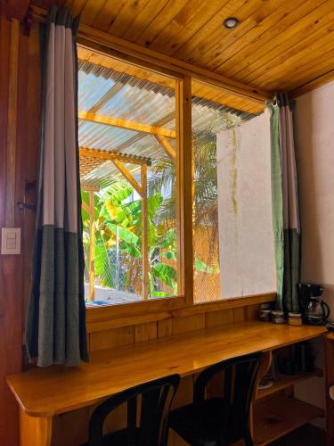Una ventana en una habitación con dos sillas delante de ella. en Cabañas del Lago, interior, en San Pedro La Laguna