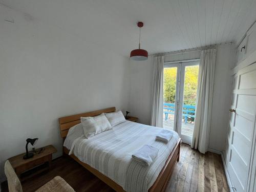 um quarto com uma cama e uma janela grande em CASONA CENTRO ZAPALLAR 12 personas em Zapallar