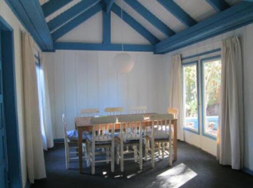 uma sala de jantar com mesa e cadeiras de madeira em CASONA CENTRO ZAPALLAR 12 personas em Zapallar