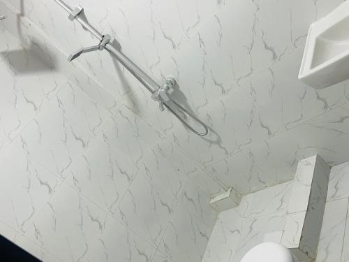 a white marble wall in a bathroom with a toilet at Relax Guest House in Luanda