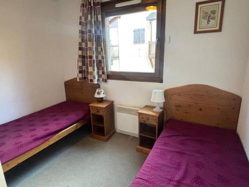 une chambre avec deux lits et une fenêtre avec des draps violets dans l'établissement Appartement 3 pièces calme avec parking et balcon, Les Angles - FR-1-593-125, aux Angles