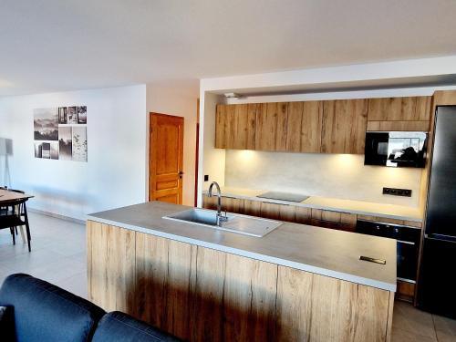 une cuisine avec un évier et un plan de travail dans l'établissement Appartement Neuf 5 pièces à 20m des pistes avec garage double - FR-1-755-37, à Aime La Plagne