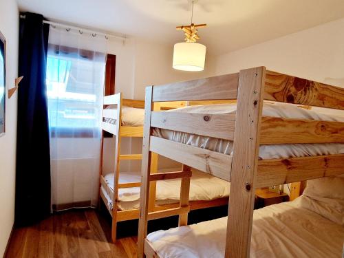 une chambre avec deux lits superposés et une fenêtre dans l'établissement Appartement Neuf 5 pièces à 20m des pistes avec garage double - FR-1-755-37, à Aime La Plagne