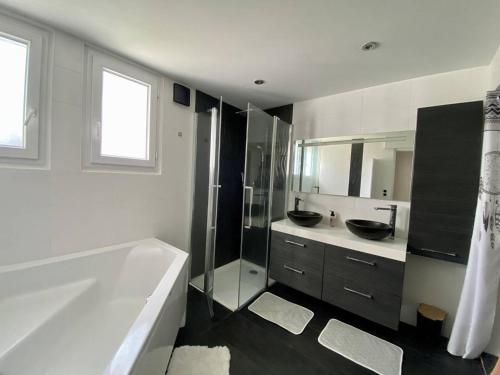 une salle de bain blanche avec une baignoire et un lavabo dans l'établissement Appartement calme à Hasparren avec jardin et Wi-Fi, 4 couchages - FR-1-495-144, à Hasparren