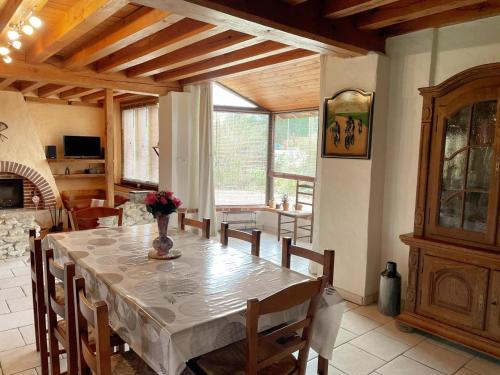 une salle à manger avec une table et un vase de fleurs. dans l'établissement Gîte en Sologne avec jardin clos, animaux admis, parking et internet - FR-1-491-454, à Neung-sur-Beuvron