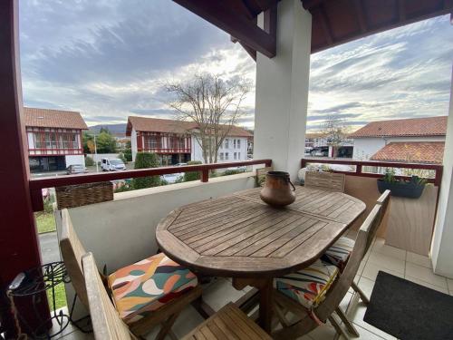 une table et des chaises en bois sur un balcon dans l'établissement Grand Studio Duplex à Cambo, Animaux Acceptés, Terrasse, Parking, Internet - FR-1-495-147, à Cambo-les-Bains