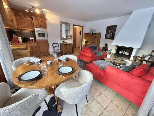 un salon avec une table et un canapé rouge dans l'établissement Charmant appartement 3 pièces, jardin, parking et wifi à Demi-Quartier - FR-1-597-187, à Demi-Quartier