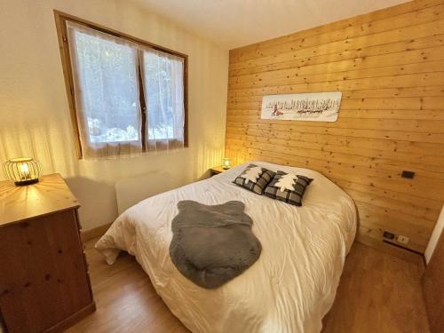 une chambre avec un lit dans un mur en bois dans l'établissement Charmant appartement 3 pièces, jardin, parking et wifi à Demi-Quartier - FR-1-597-187, à Demi-Quartier