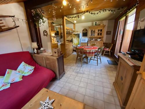 un salon avec un canapé rouge et une table dans l'établissement Charmant appartement proche centre, parking inclus - FR-1-692-109, à Abondance