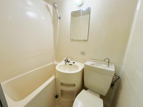 a bathroom with a toilet and a sink and a bath tub at avanti house大橋A3 in Shiobaru