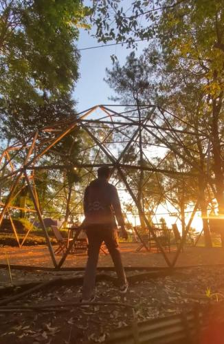 a man standing in front of a metal structure at vanderman land camp in Batu