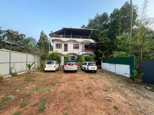 three cars parked in front of a house at Marari Beach Villas in Mararikulam