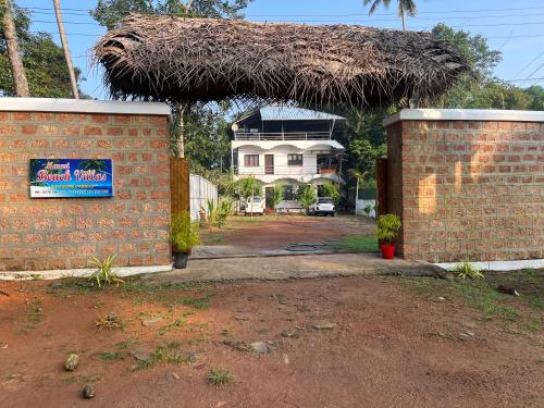 a house with a sign in front of it at Marari Beach Villas in Mararikulam