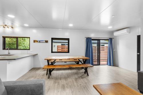 a living room with a table and a kitchen at North South Holiday Park in Christchurch