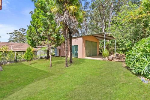 a house with a green garage in a yard at Retro Retreat in Manyana