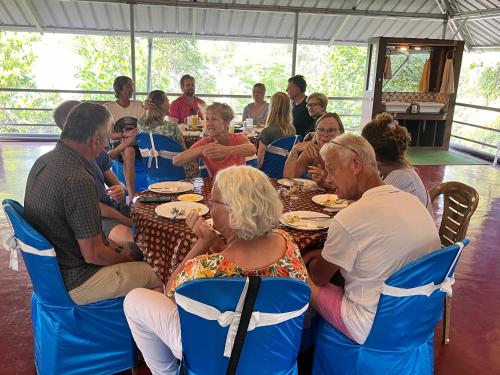 a group of people sitting at a table eating at Marari Beach Villas in Mararikulam