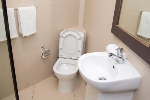 a bathroom with a white toilet and a sink at Garden Apartments in Nadi