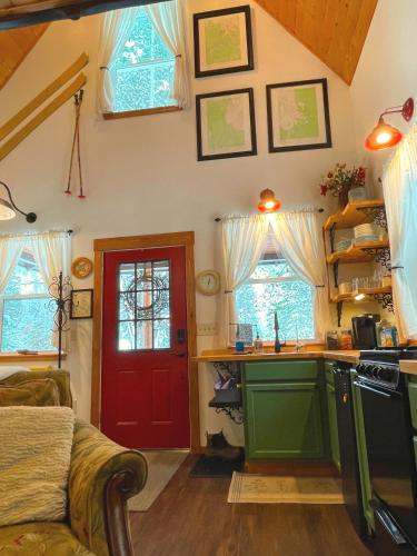 a kitchen with a red door and some windows at Kataluma Inn, Sandpoint, Idaho - Entire Cozy Cabin, Pet Friendly in Sandpoint