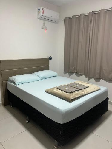 ein Bett mit einer Decke auf dem Zimmer in der Unterkunft Família Nadin in Penha