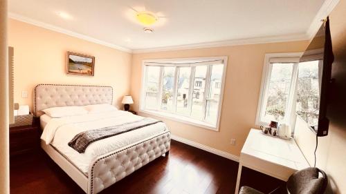 a bedroom with a white bed and two windows at Coze home in Vancouver near YVR in Vancouver
