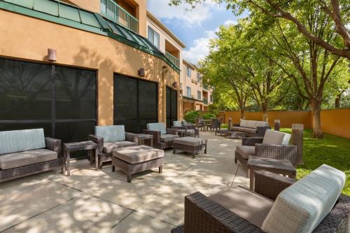 a patio with chairs and tables in front of a building at Courtyard Lubbock in Lubbock