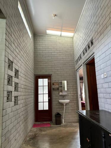 a bathroom with a sink and a white brick wall at Villa Tagar Hidayah in Ciwidey