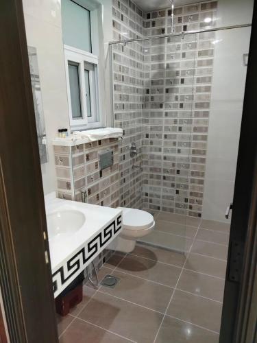 a bathroom with a sink and a toilet and a shower at Ambrina Hotel in Islamabad