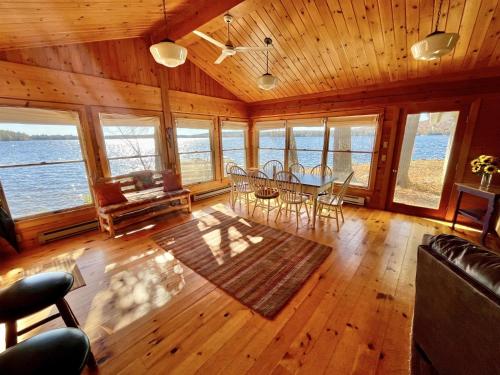 a living room with a table and chairs and the ocean at BEAR POINT LIMIT 15 villa in Harrison