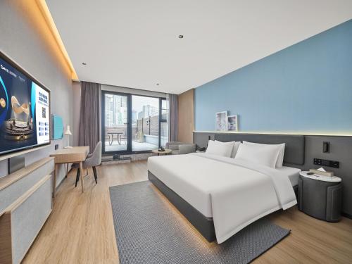 a hotel room with a large bed and a tv at Country Inn&Suites By Radisson, Xi'an Bell and Drum Tower Flagship in Xi'an