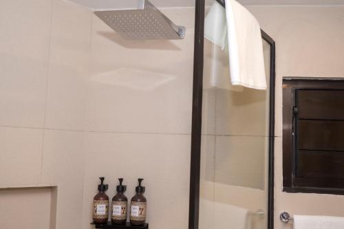 a bathroom with bottles on a shelf next to a shower at Garden Apartments in Nadi