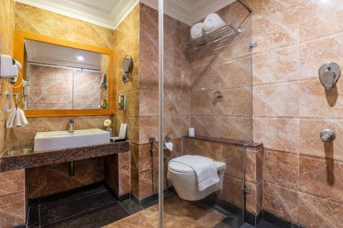 a bathroom with a toilet and a sink and a shower at Sterling V Grand Madurai in Madurai