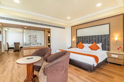 a hotel room with a bed and a chair at Sterling V Grand Madurai in Madurai